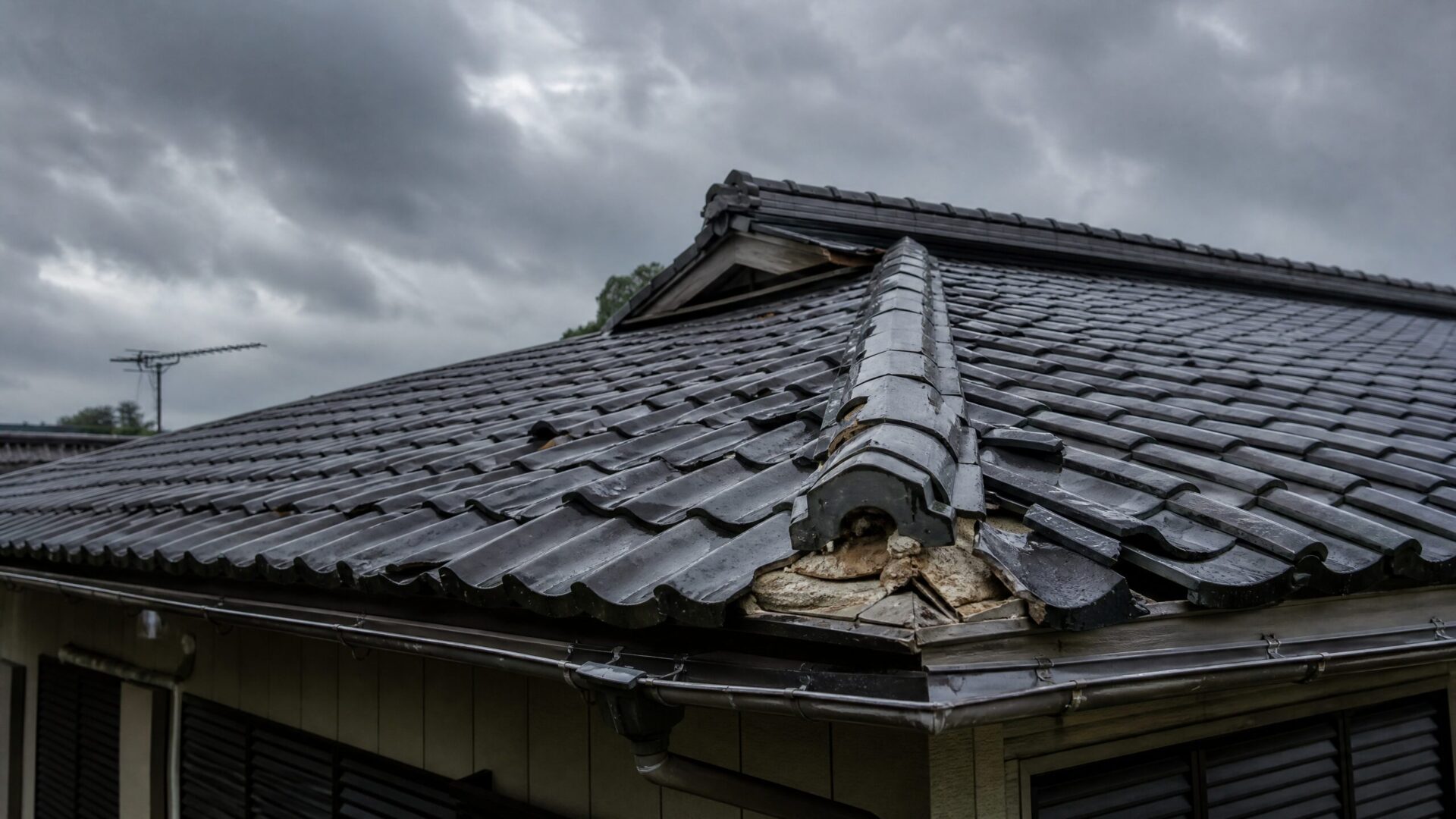 台風の強風により瓦がずれ、下地が見えてしまっている住宅の屋根